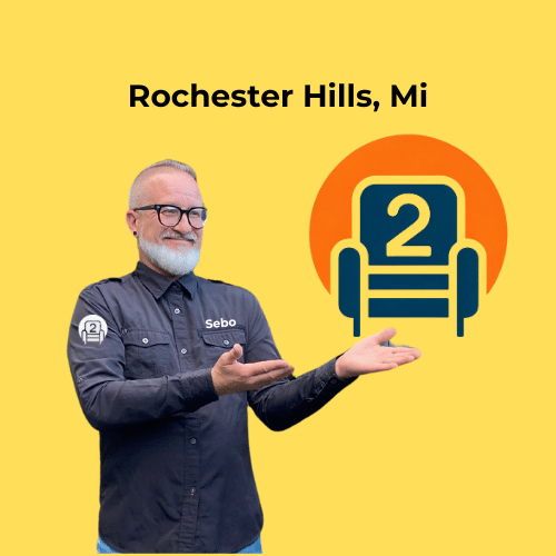 Sebo from Number2project Mobile Furniture Repair pointing towards the company logo, promoting sofa and recliner repair services in Rochester Hills, MI.