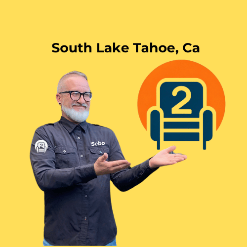 Sebo from Number2project Mobile Furniture Repair pointing at the company logo, advertising sofa and recliner repair services in South Lake Tahoe, CA.