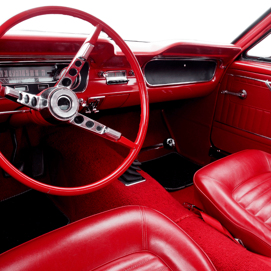 Bright red classic car interior with restored leather seats and vintage dashboard, completed by Jim’s Auto Tops & Upholstery, the best car upholstery shop in Folsom, CA.