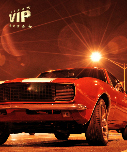 Vintage red muscle car under streetlight with VIP star badge, restored by Jim’s Auto Tops & Upholstery, the best car upholstery shop in Folsom, CA.